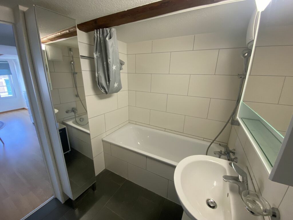 Kleines Badezimmer mit Badewanne und Waschbecken