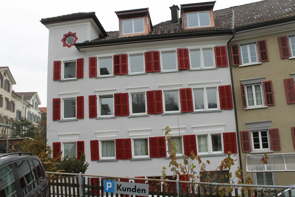 Wohnhausfassade mit roten Fensterläden