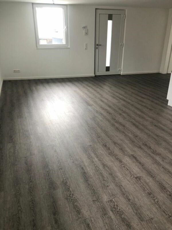 Leerer Innenraum mit dunklem Boden und Tür