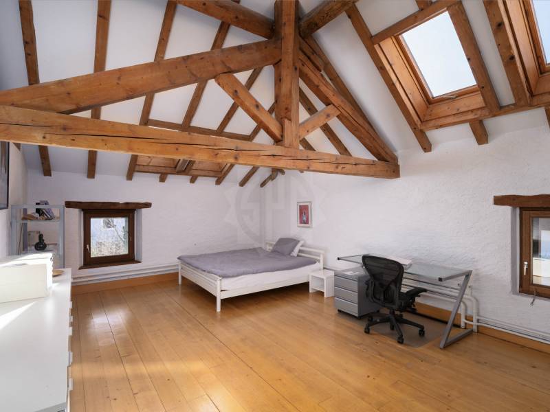Dachgeschoss-Schlafzimmer mit sichtbaren Holzbalken