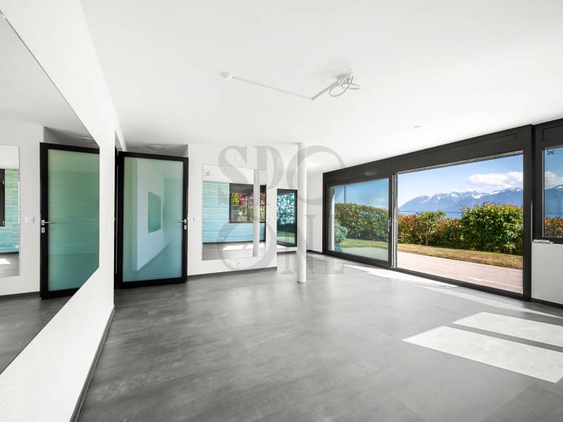Großer leerer Wohnraum mit Panoramafenster und Seeblick