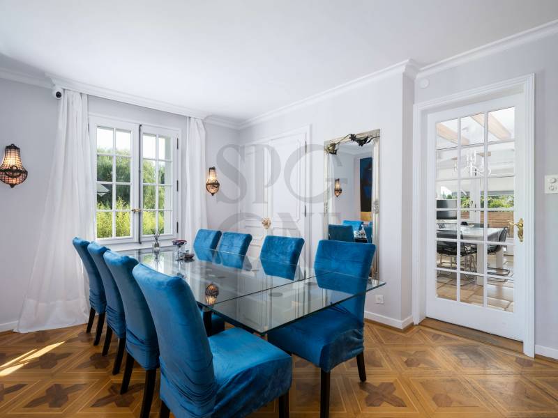 Esszimmer mit Glastisch und blauen Stühlen