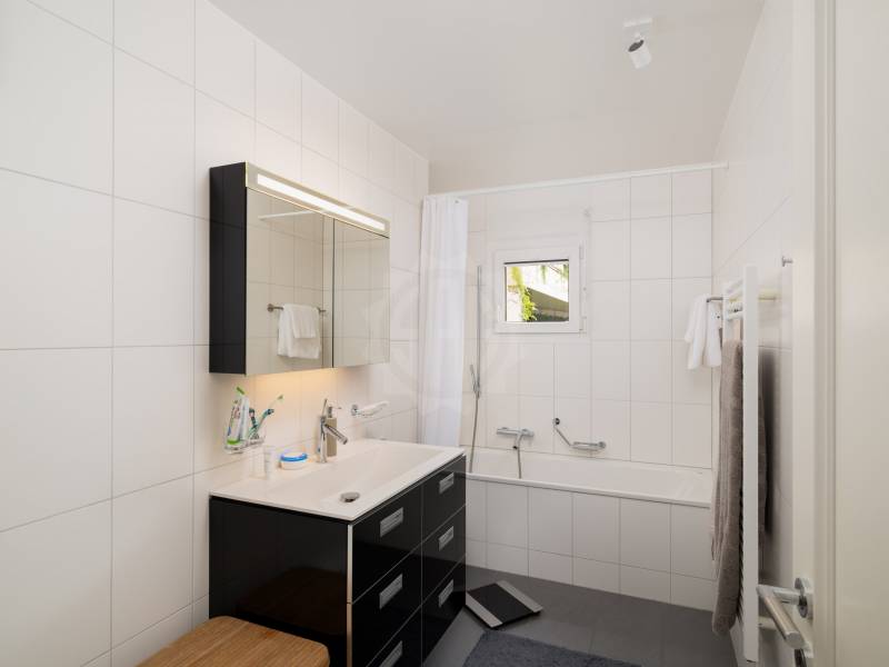 Helles, modernes Badezimmer mit Wannenbereich und Waschtisch