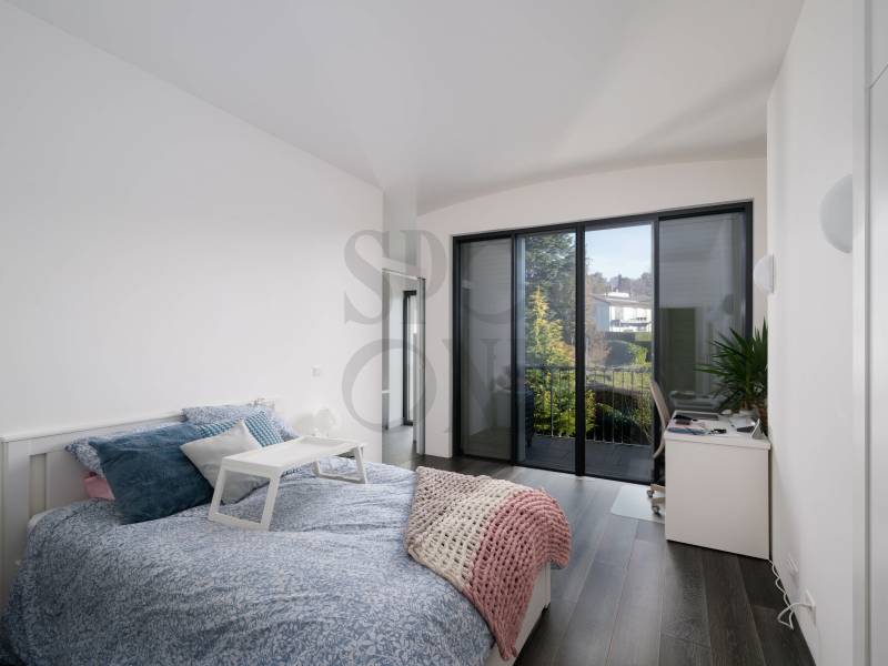 Helles Schlafzimmer mit Balkon und moderner Einrichtung