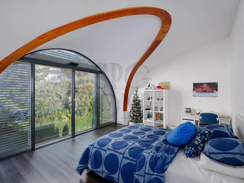 Modernes Schlafzimmer mit großer Bogenverglasung