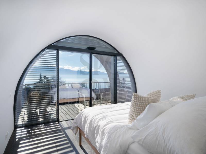 Schlafzimmer mit Rundbogenfenster und Meerblick