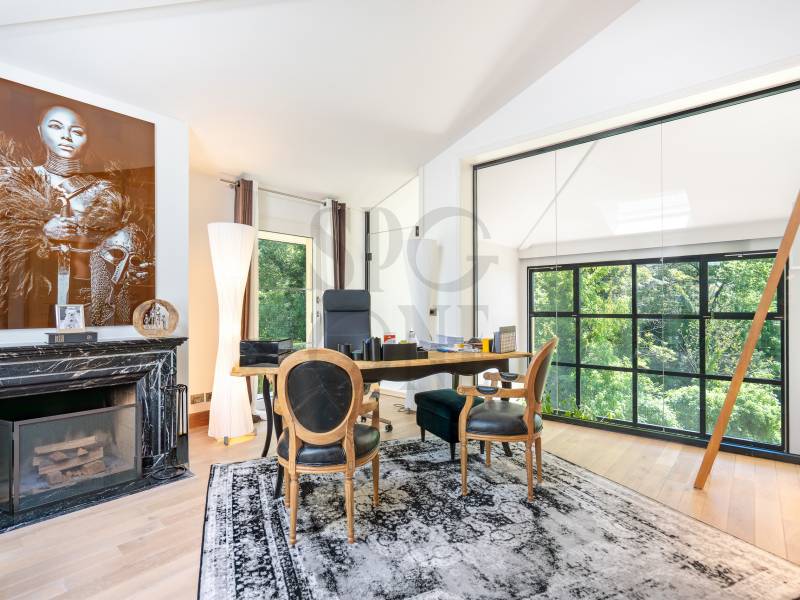 Elegantes Arbeitszimmer mit Kamin und großer Fensterfront