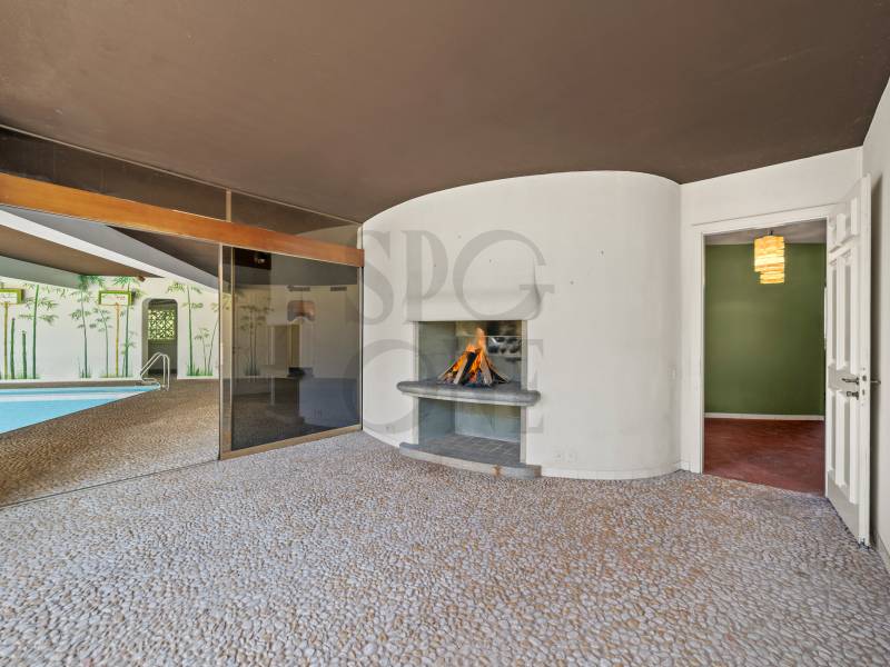 Wohnraum mit Kamin und Blick zum Poolbereich