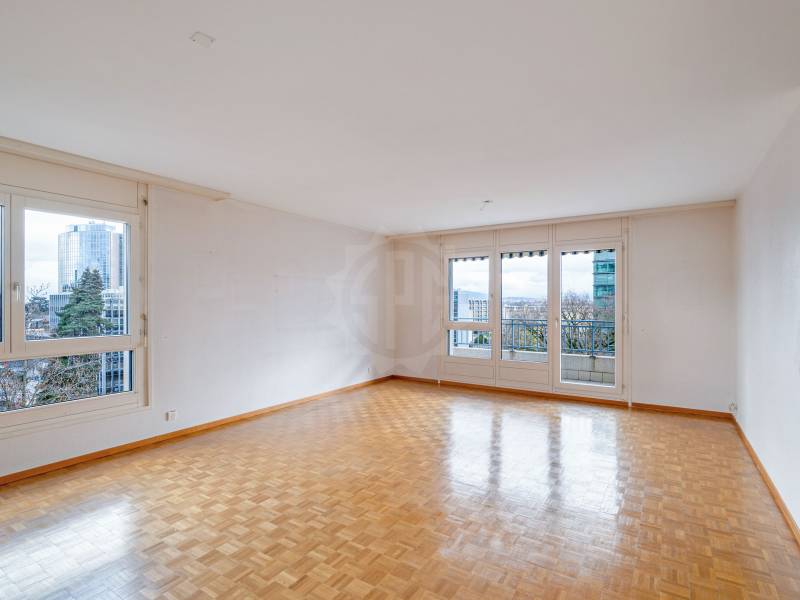 Heller leerer Wohnraum mit großen Fenstern und Balkonblick