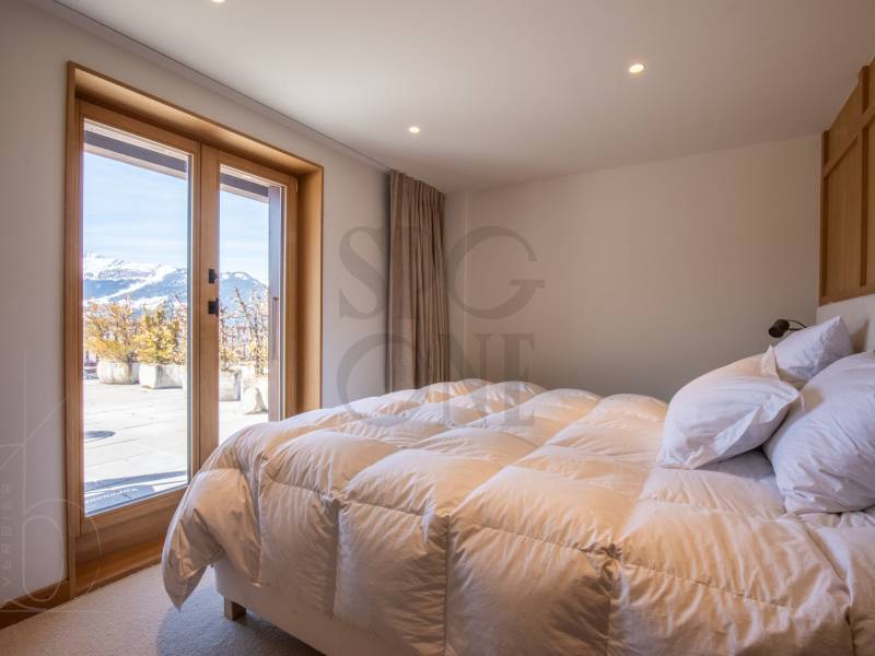 Schlafzimmer mit Terrassentür und Bergblick