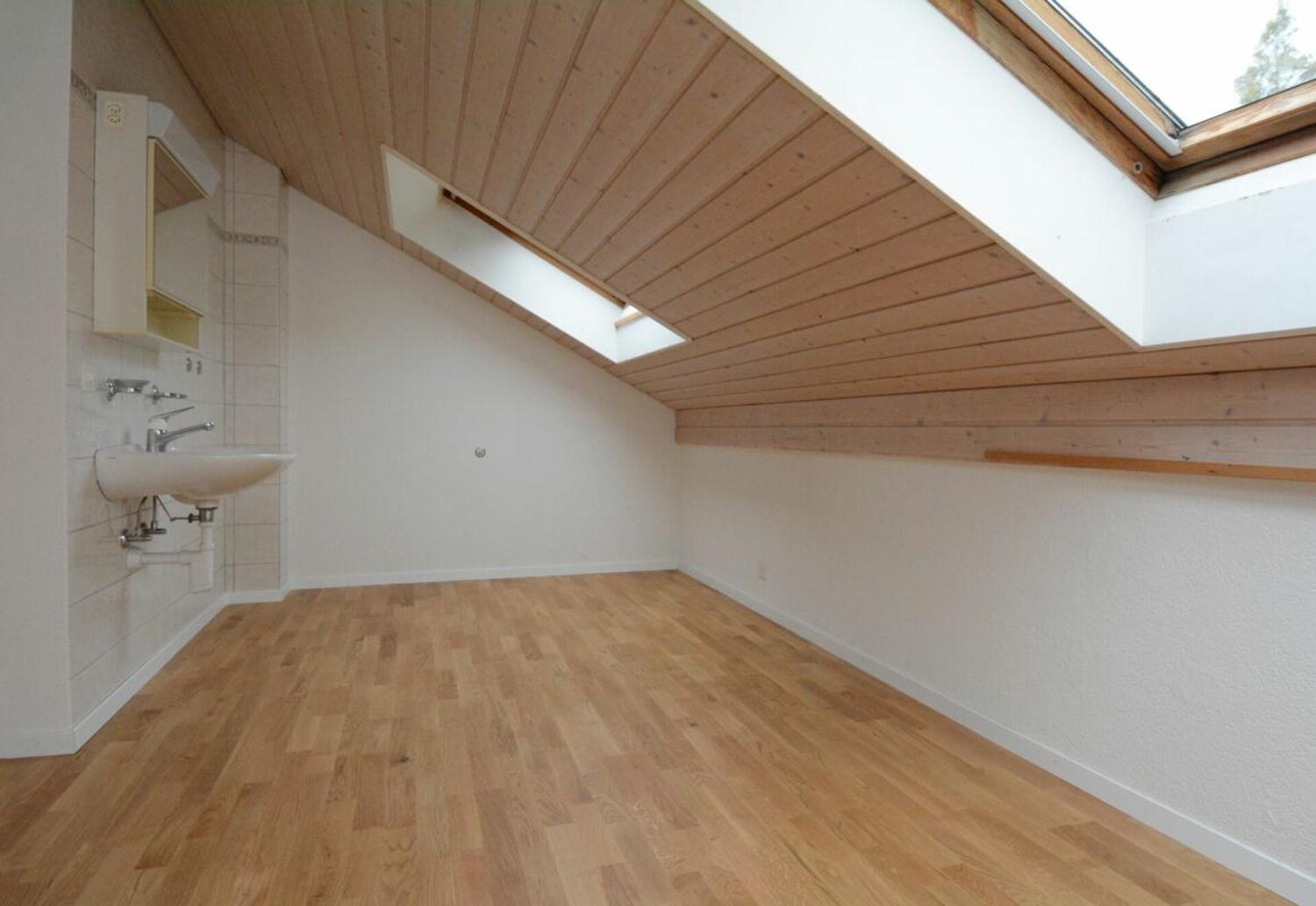 Dachgeschosszimmer mit Dachfenstern und Waschbecken