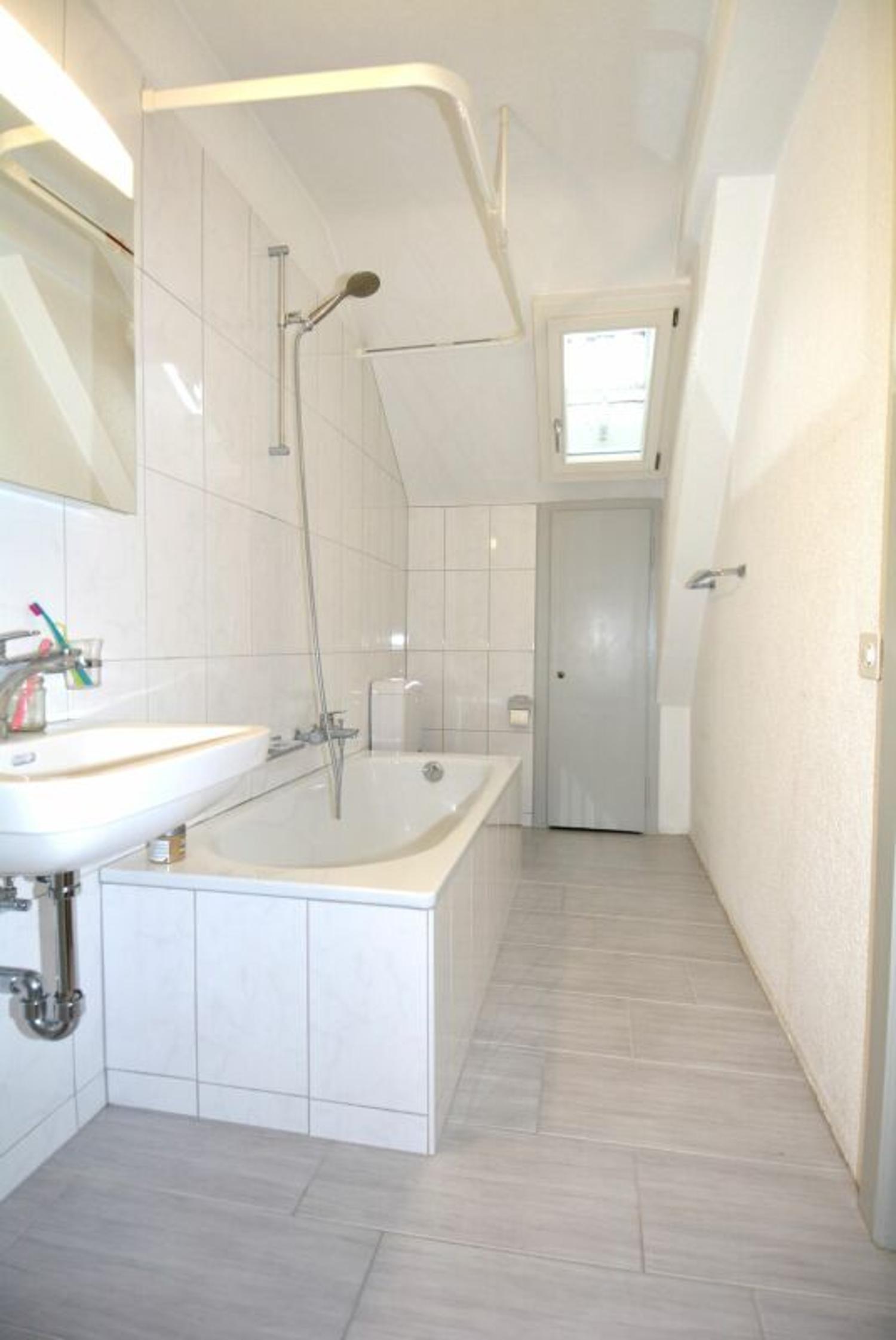 Schmales Badezimmer mit Badewanne und Dusche