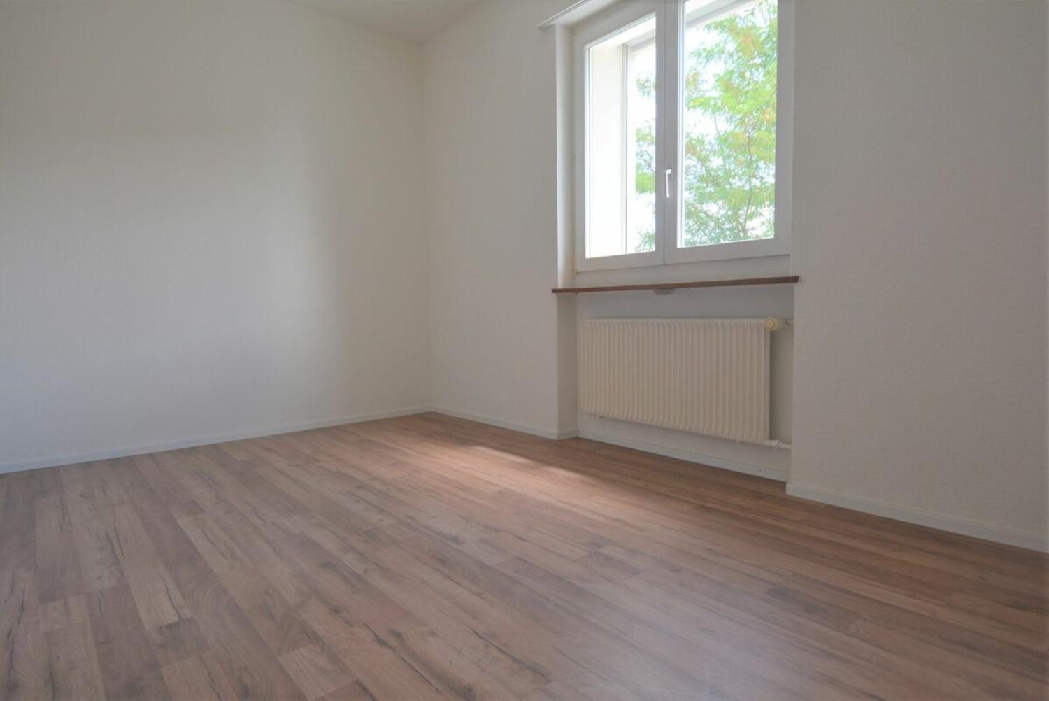 Leerer heller Raum mit Fenster und Heizkörper