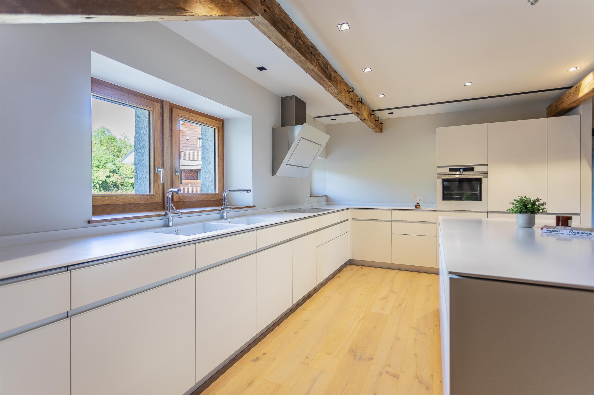 Moderne helle Küche mit sichtbaren Holzbalken