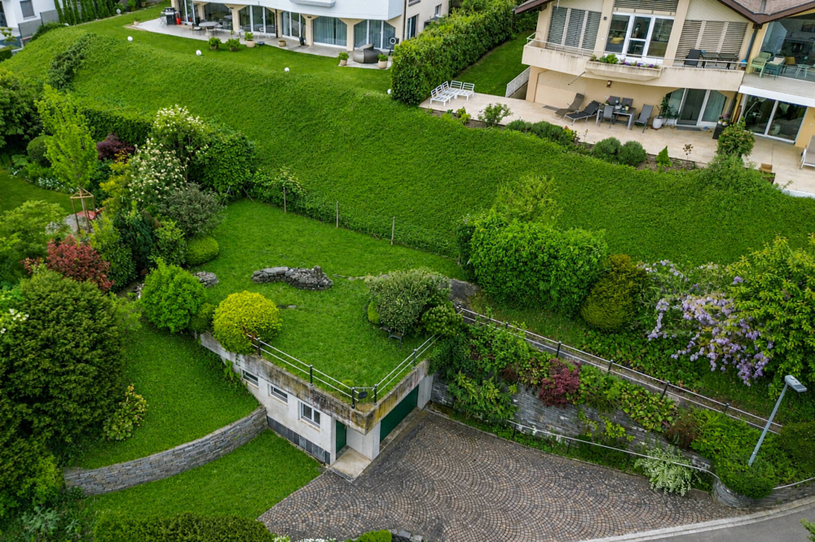 Grüne Hanglage mit Wohngebäuden und Garten