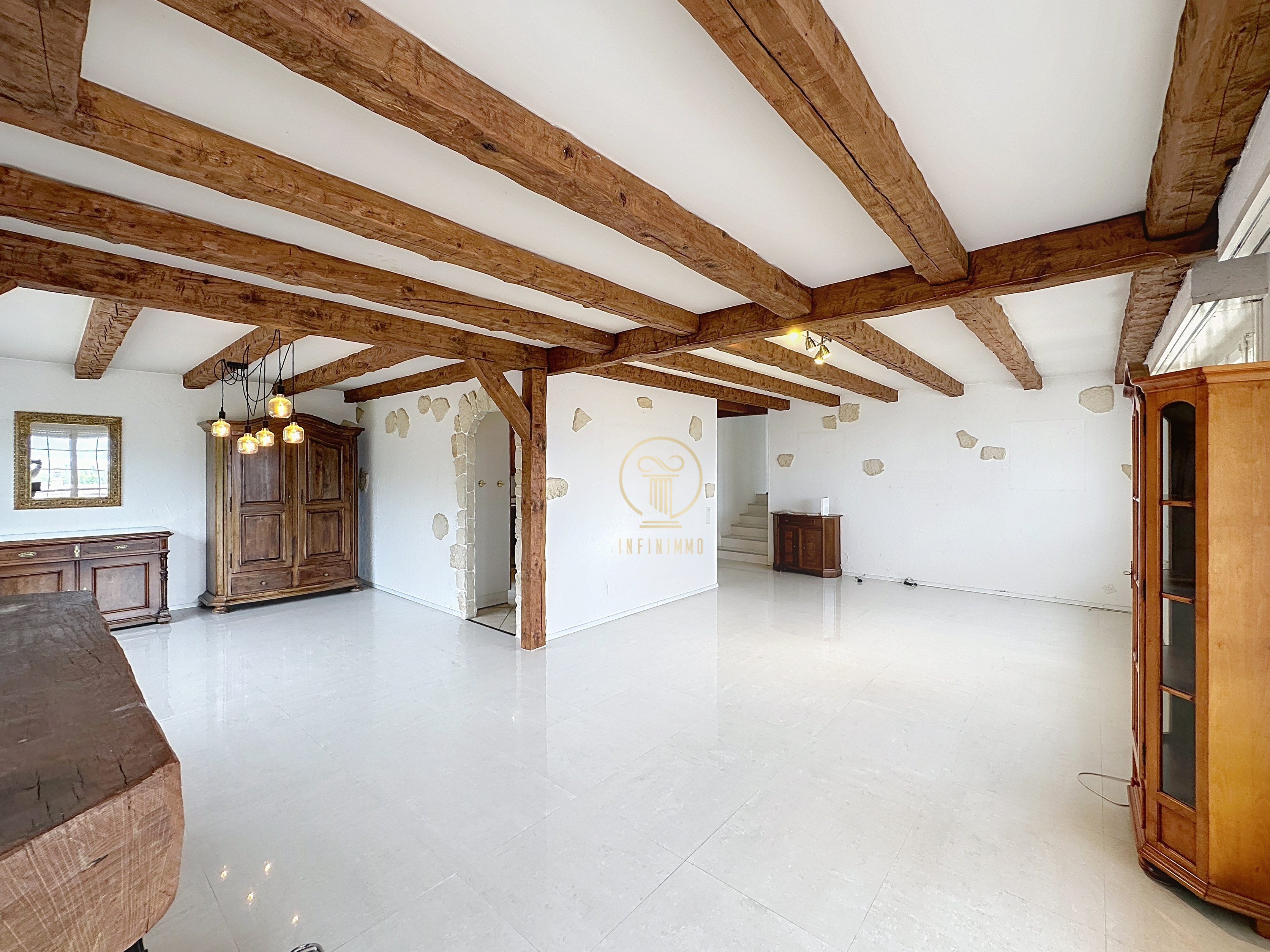 Großer Wohnraum mit sichtbaren Holzbalken