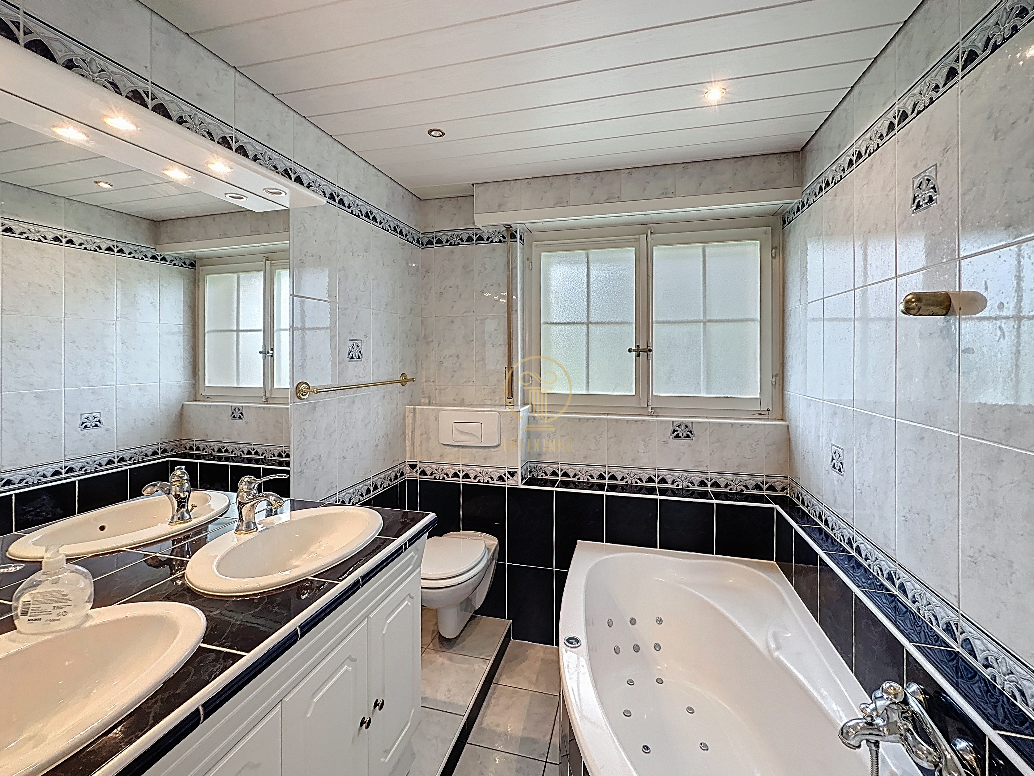 Helles Badezimmer mit Doppelwaschbecken und Badewanne