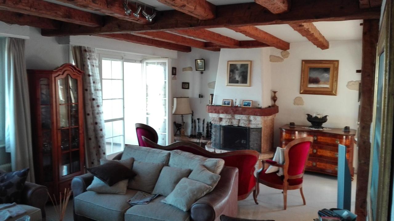Rustikales Wohnzimmer mit Kamin und sichtbaren Holzbalken