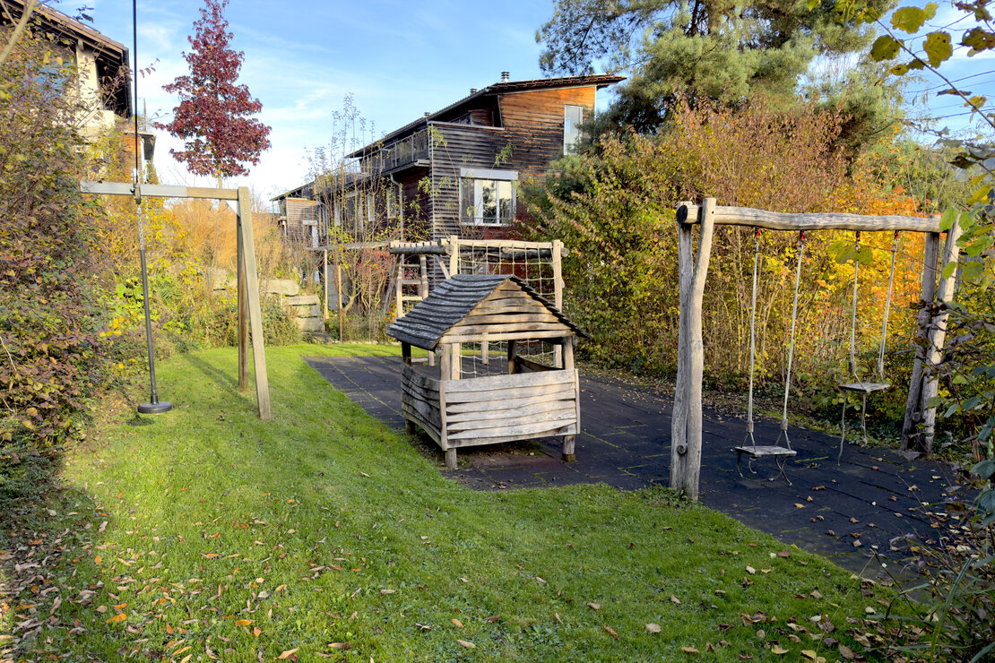 Garten mit Spielgeräten und Holzhaus