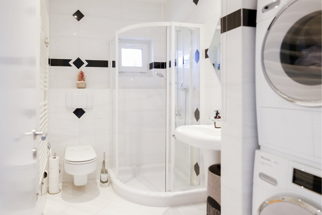 Modernes Badezimmer mit Duschkabine und Waschmaschine