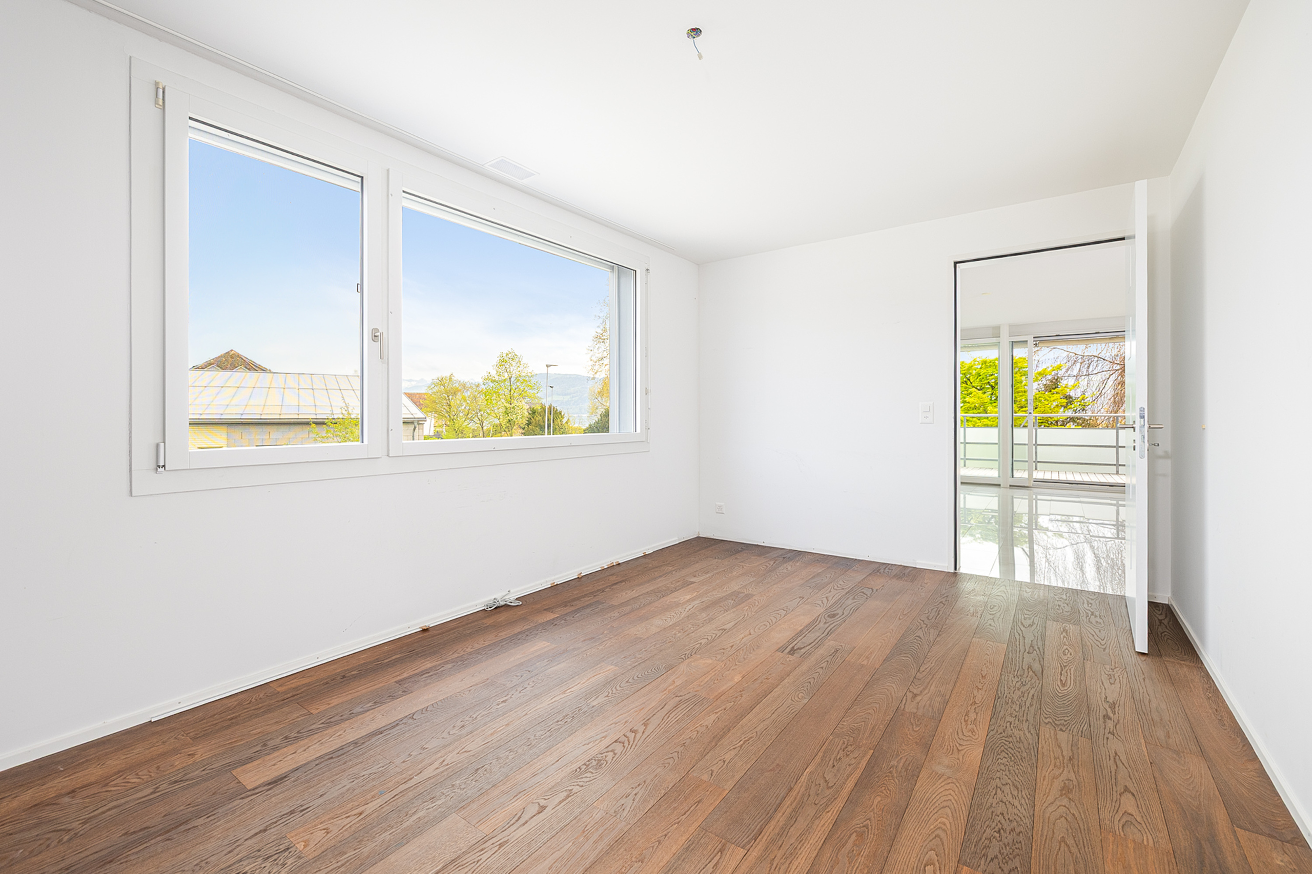 Helles, leeres Zimmer mit Holzfußboden