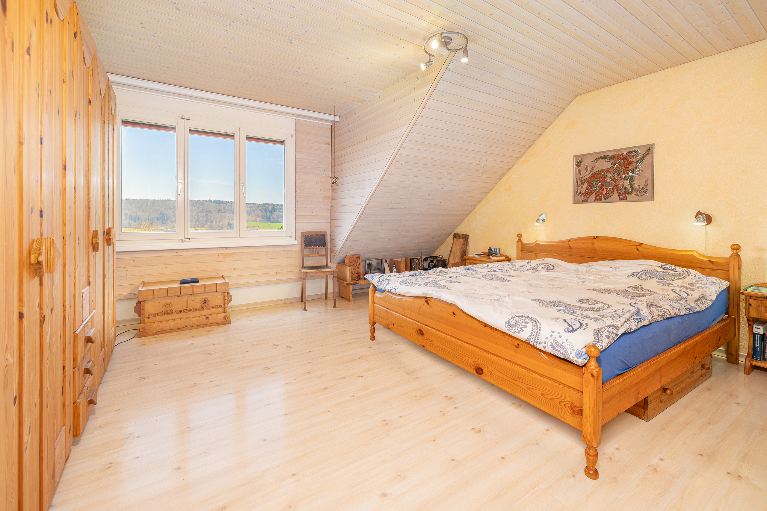 Gemütliches Schlafzimmer mit Holzverkleidung und Bergblick