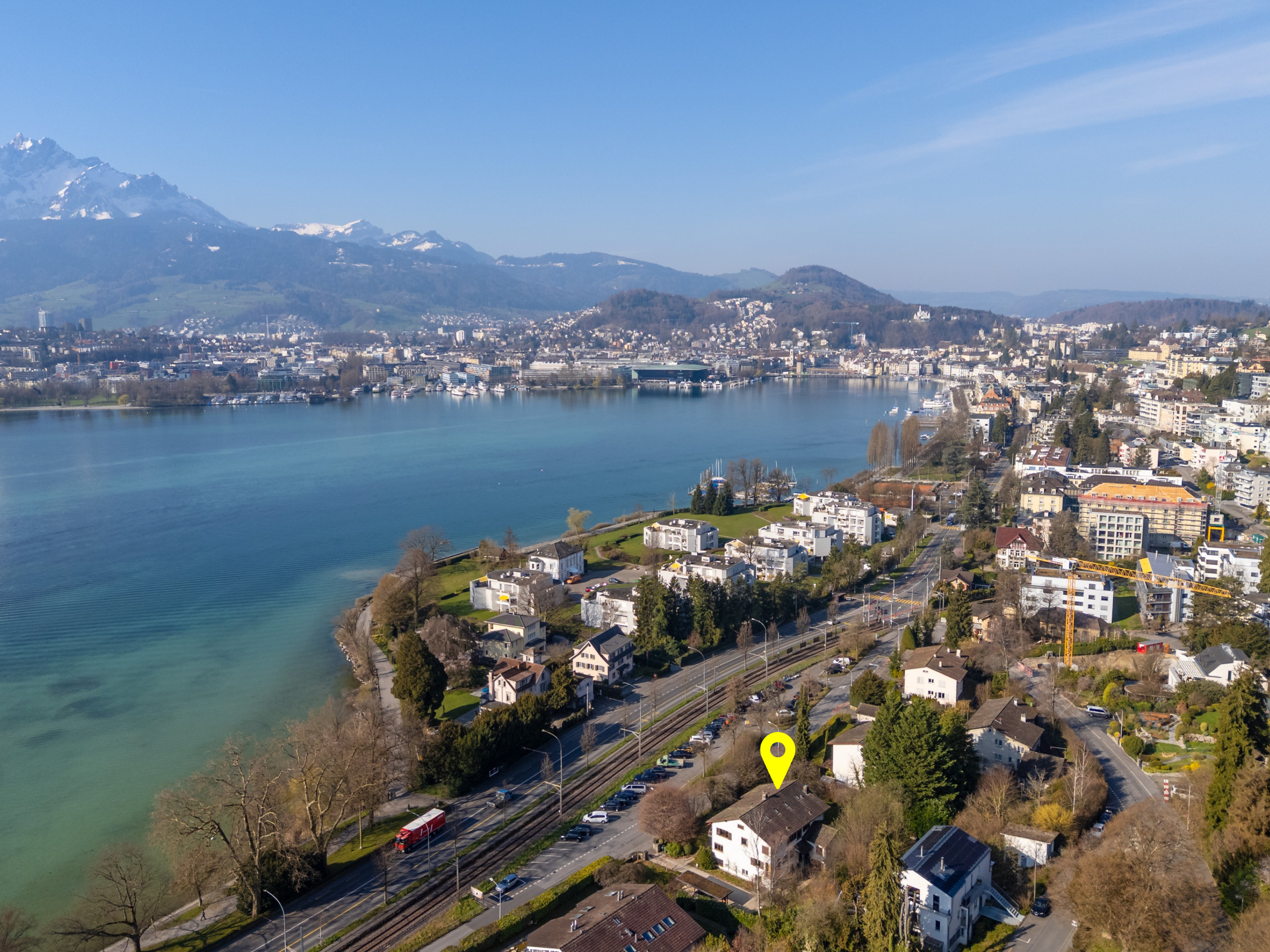 Luftaufnahme einer Stadt am See mit Alpenpanorama