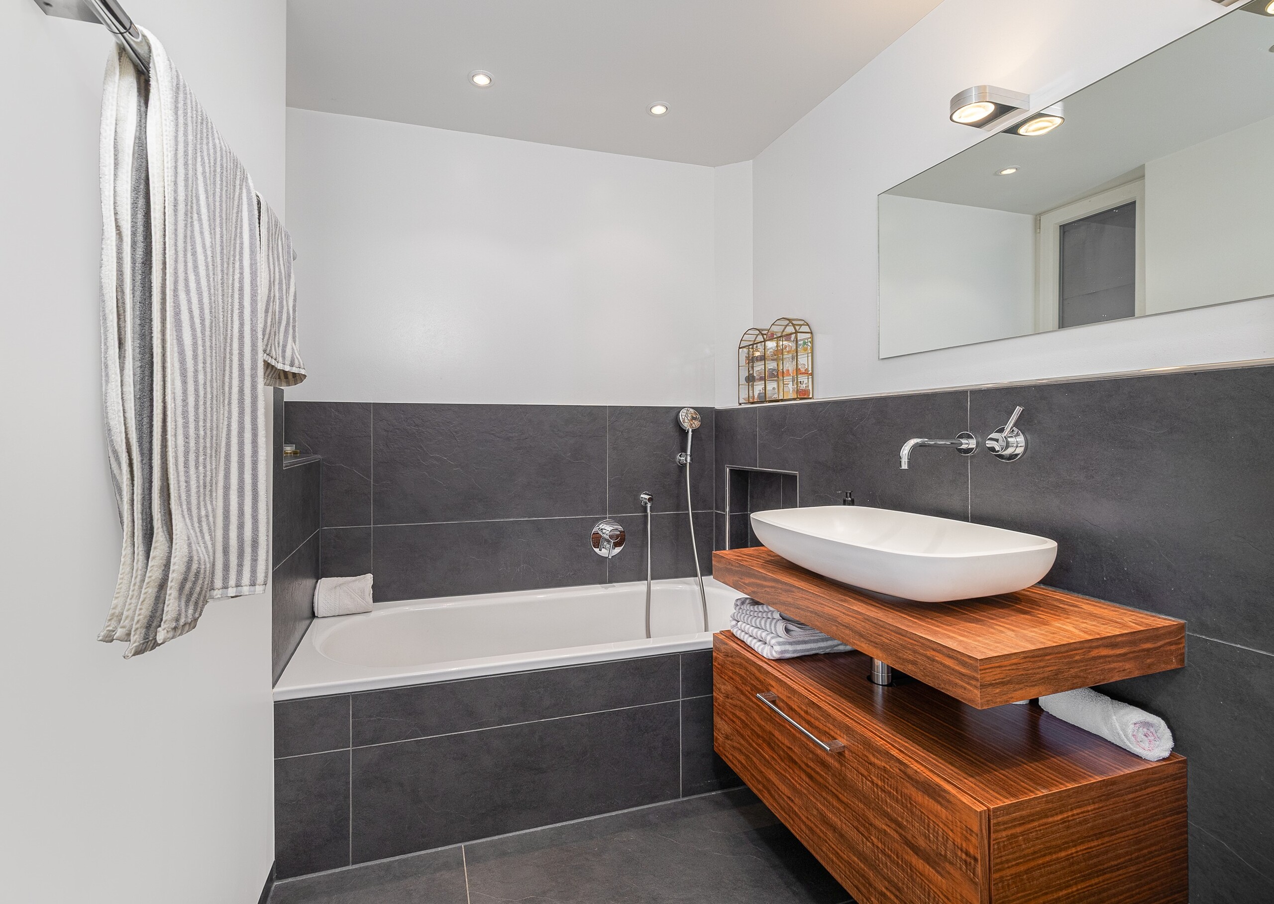 Modernes Badezimmer mit Badewanne und Holzwaschtisch