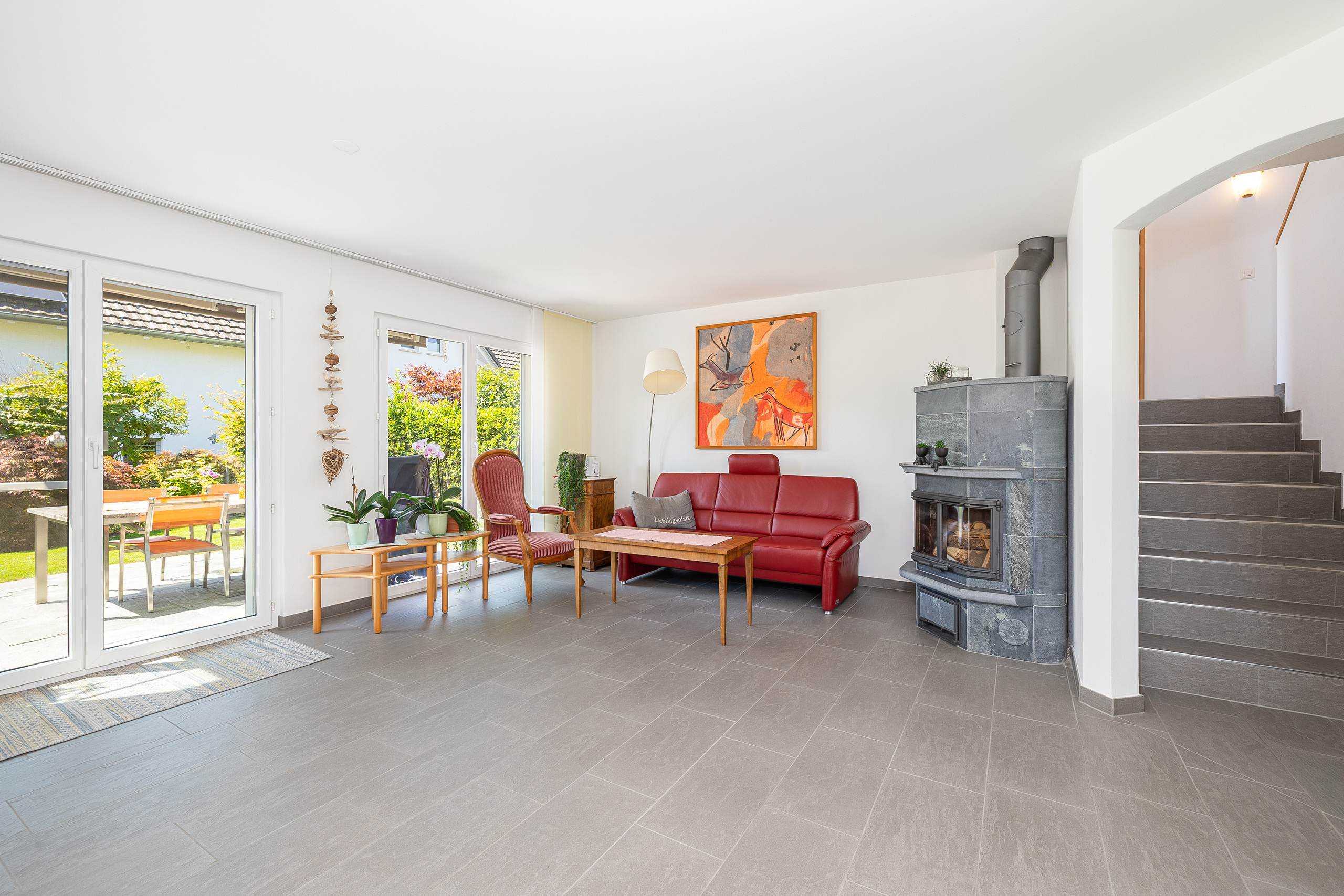 Heller Wohnraum mit Kamin und Gartenzugang