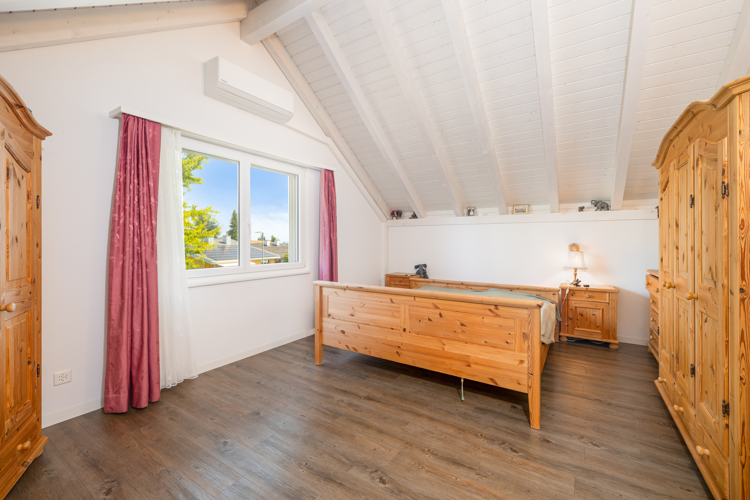 Helles Dachgeschoss-Schlafzimmer mit Holzmöbeln