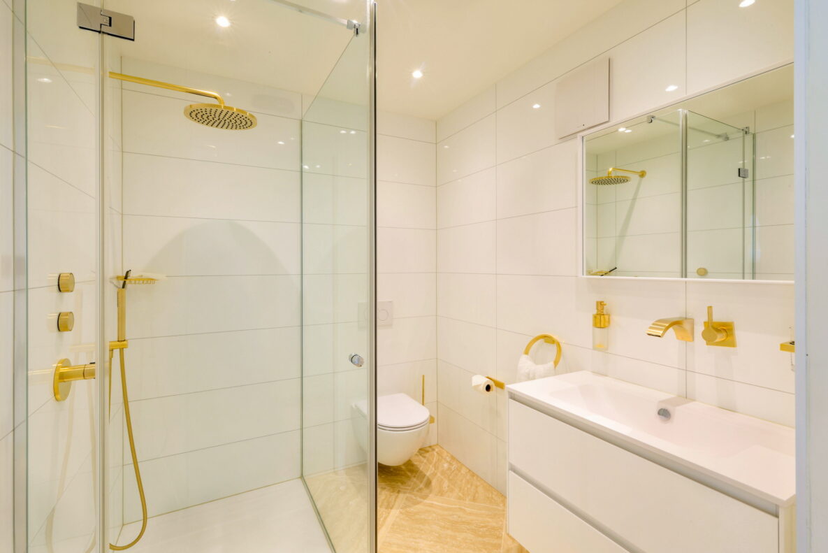 Modernes Bad mit goldenen Armaturen