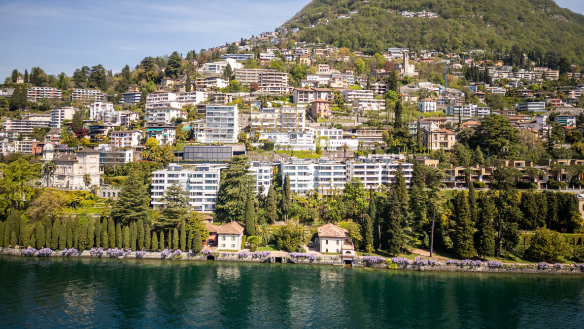 Uferstadt am See mit Hügellandschaft