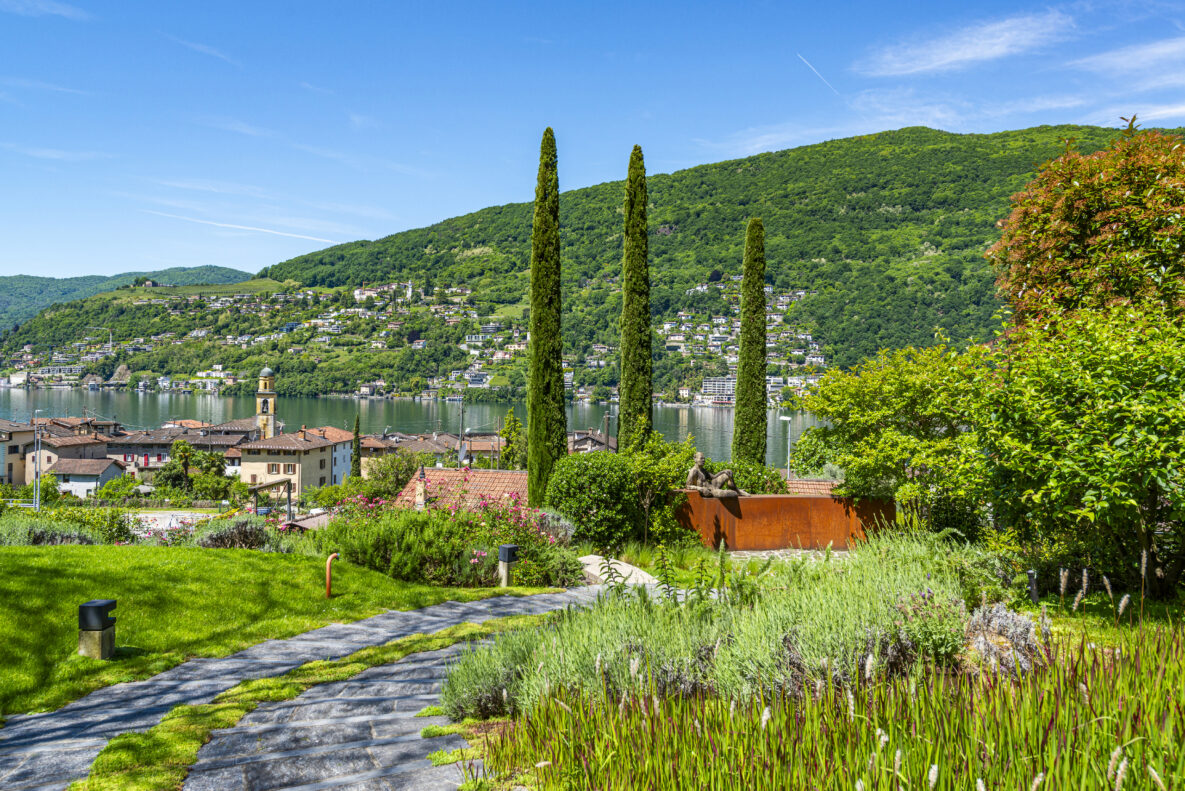 See mit Garten und Bergpanorama