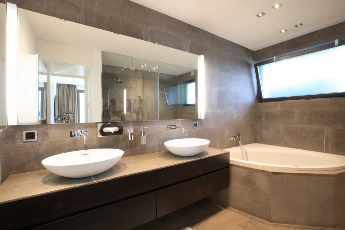 Modernes Badezimmer mit Doppelwaschbecken und Eckbadewanne