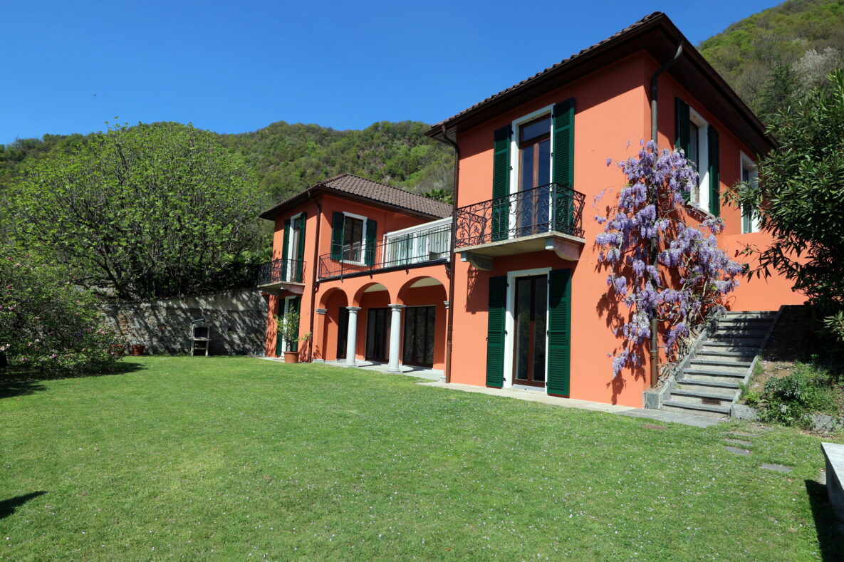Orangefarbenes Landhaus mit Garten und Balkon