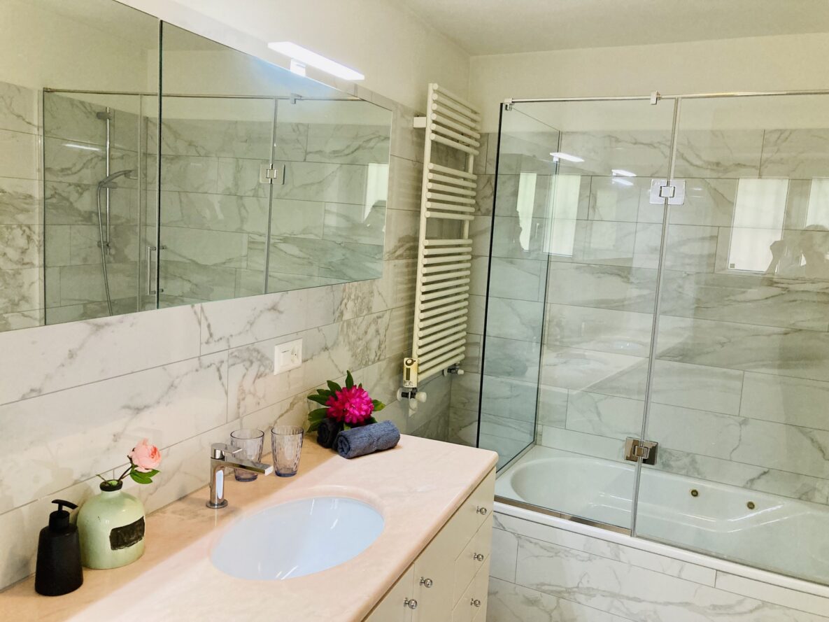 Modernes Badezimmer mit Glasdusche und Marmoroptik