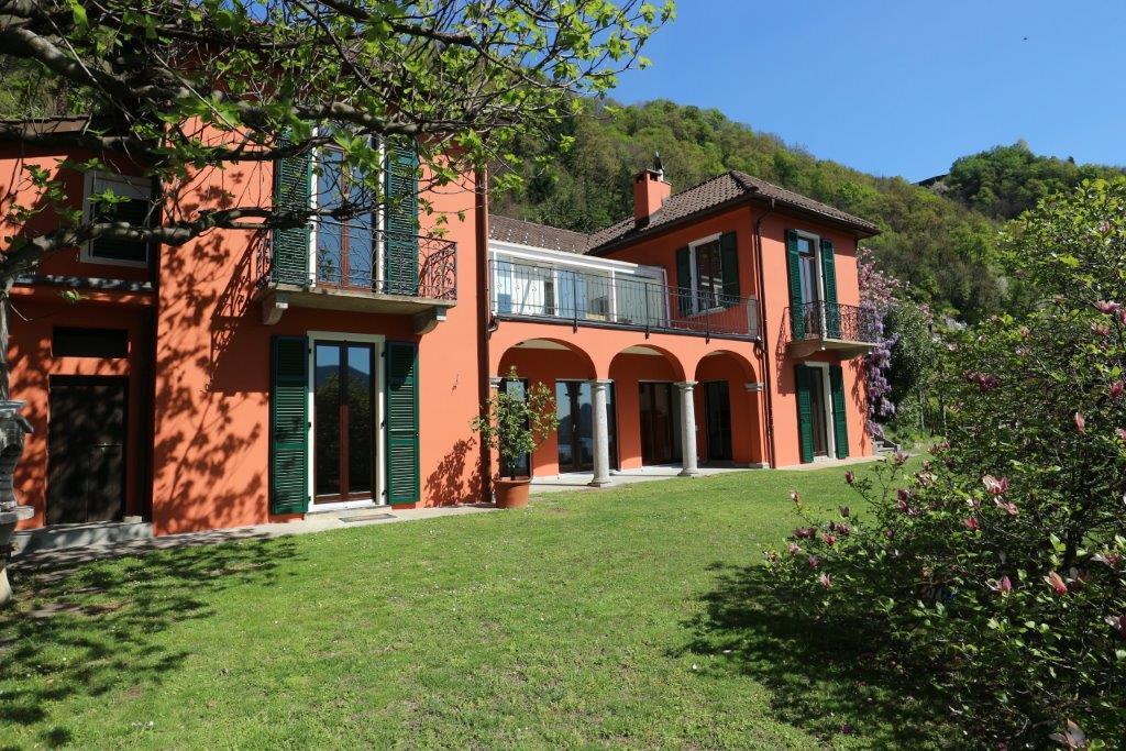 Korallfarbenes Landhaus mit Balkon und Garten