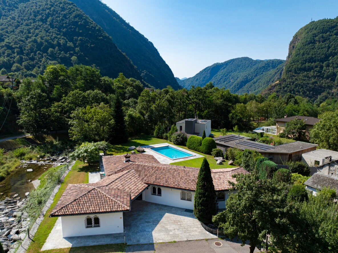 Luftaufnahme eines Anwesens mit Pool und Bergkulisse