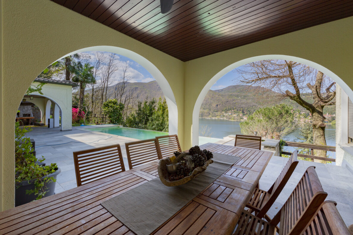 Überdachte Terrasse mit Pool- und Seeblick