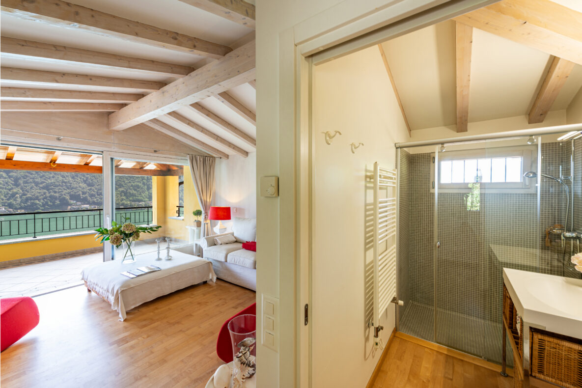 Wohnraum mit Zugang zum Balkon und angrenzendem Bad