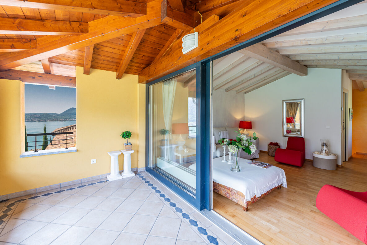 Überdachter Balkon mit Seeblick und offenem Zugang zum Wohnraum