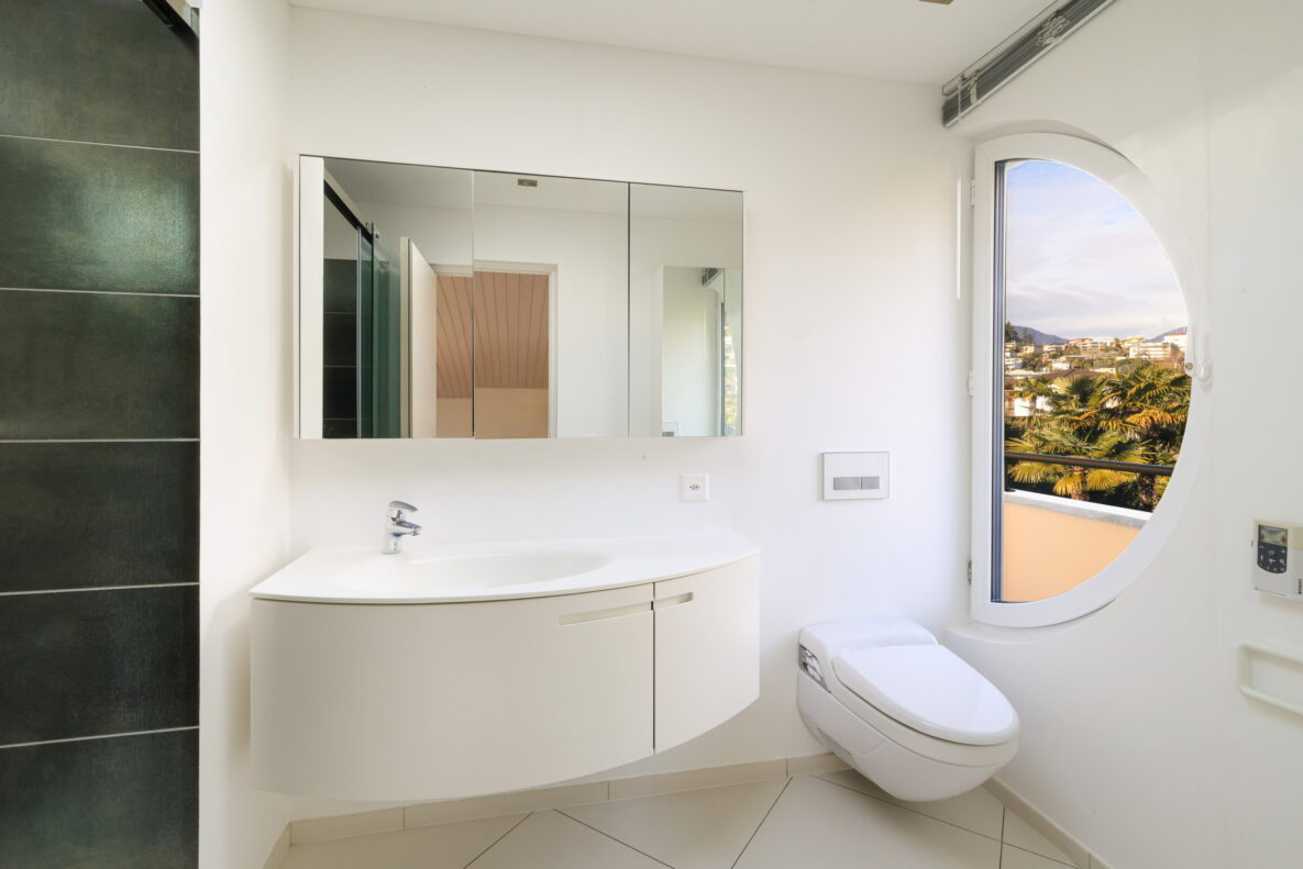 Modernes Badezimmer mit Fenster und wandhängendem WC