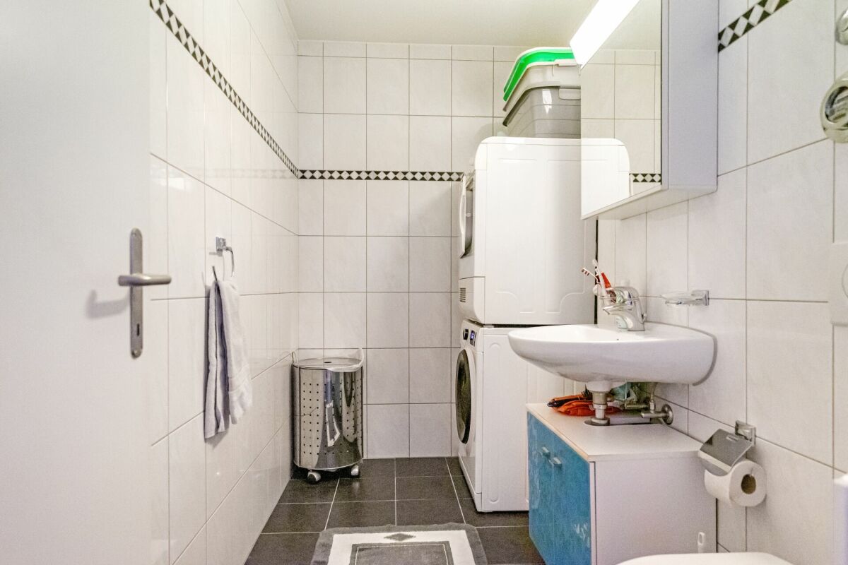 Hauswirtschaftsraum mit Waschmaschine und Waschbecken