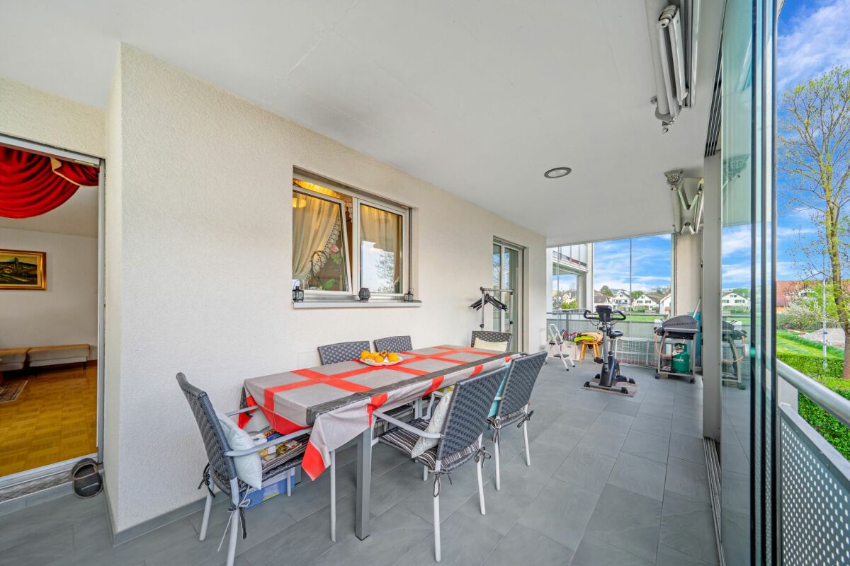 Überdachter Balkon mit Ess- und Fitnessbereich