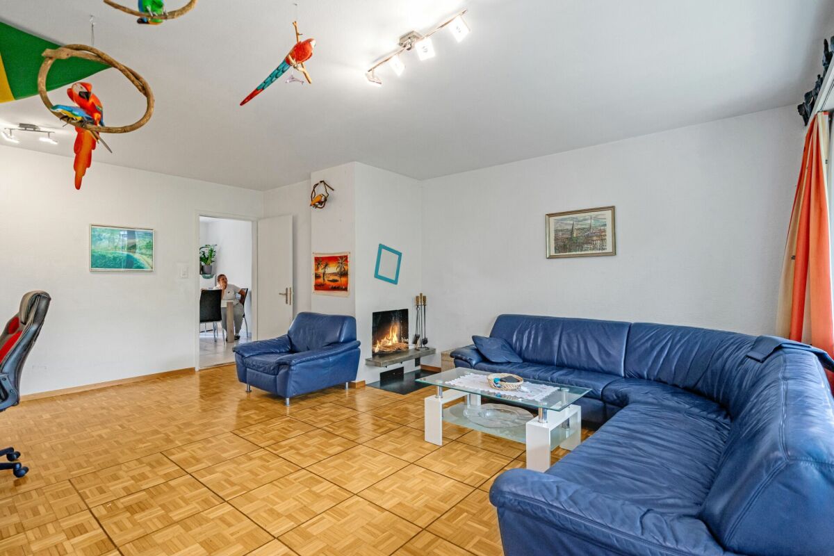 Wohnzimmer mit blauen Sofas und Holzparkett