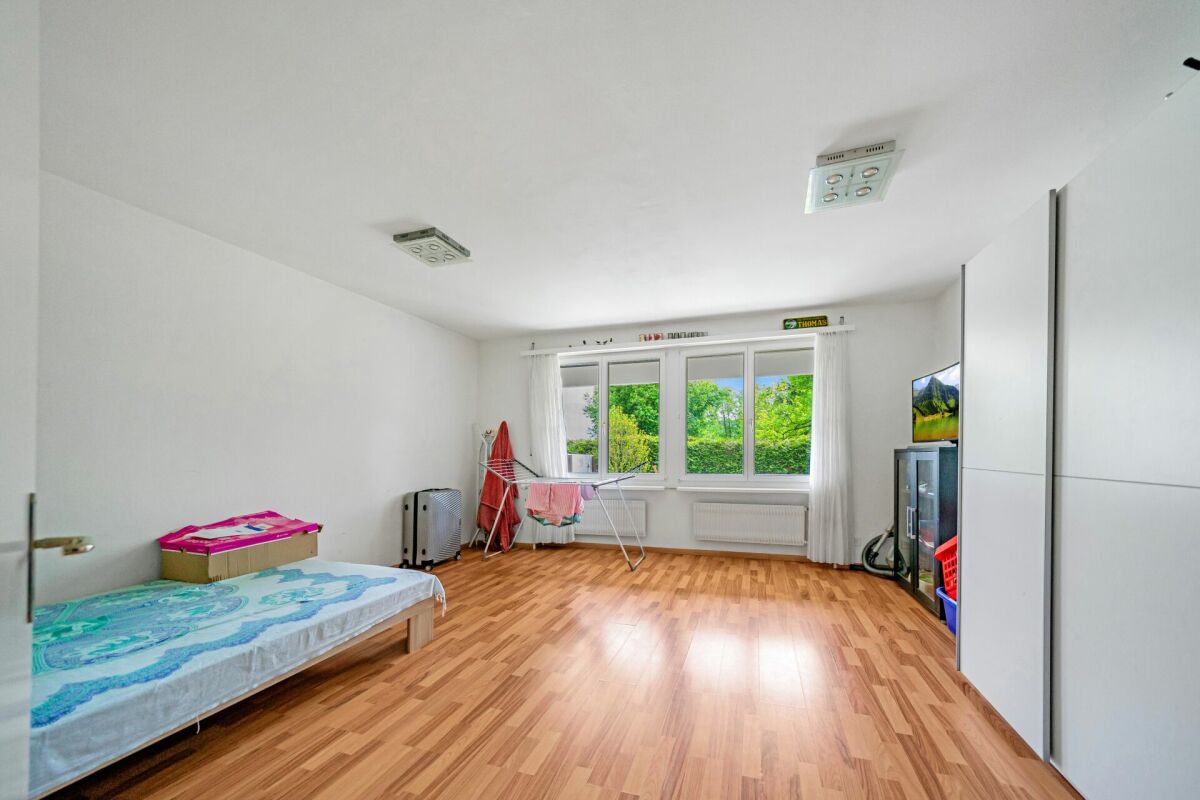 Helles Schlafzimmer mit Holzfußboden und großem Fenster