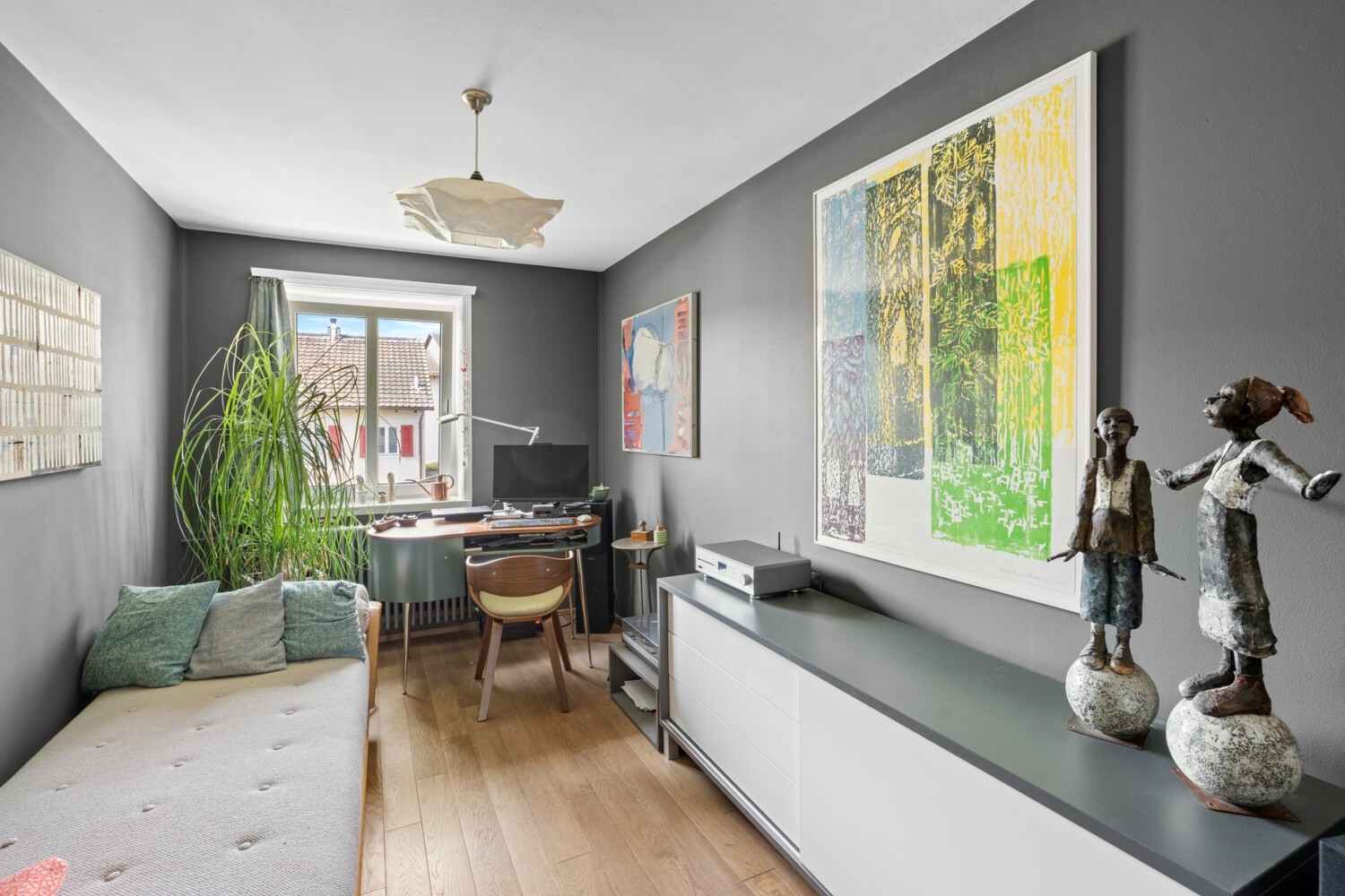 Helles Arbeitszimmer mit Kunst und Grünpflanze
