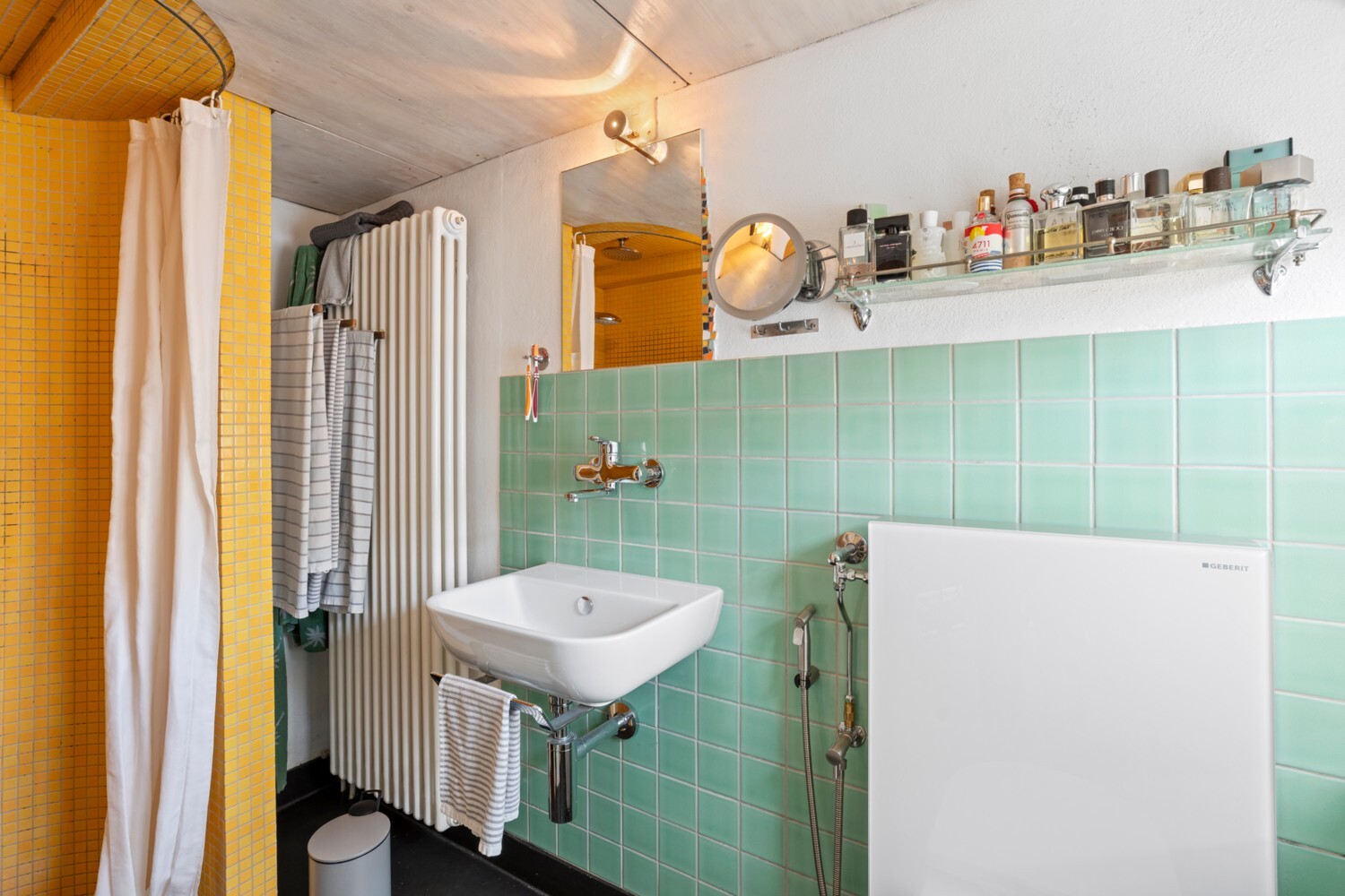Badezimmer mit farbigen Fliesen und Waschplatz