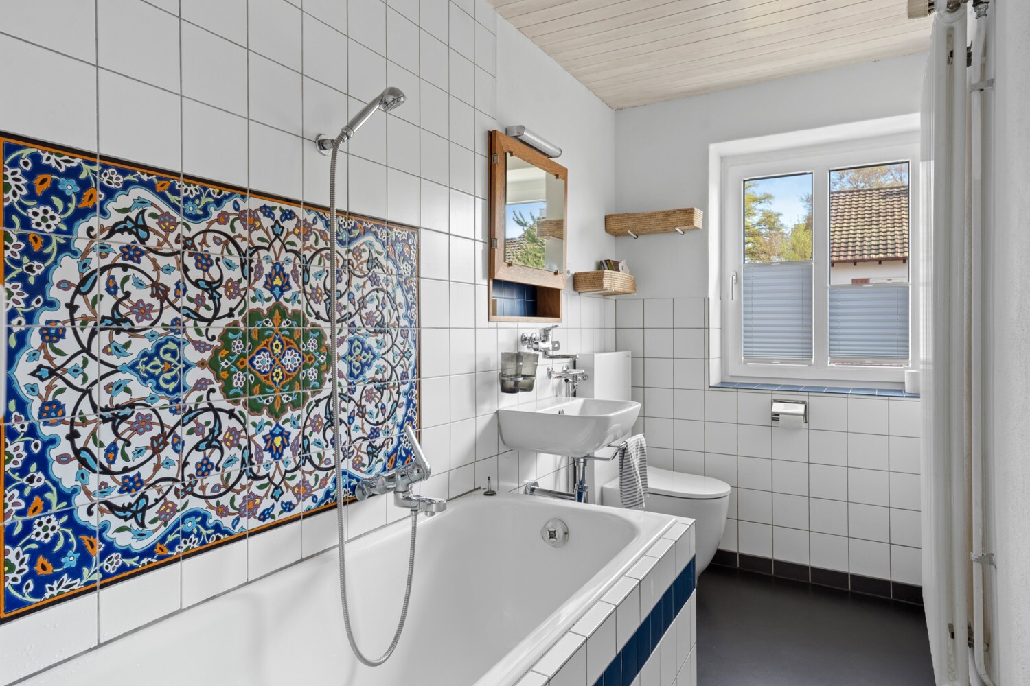 Badezimmer mit Badewanne und dekorativer Fliesenwand