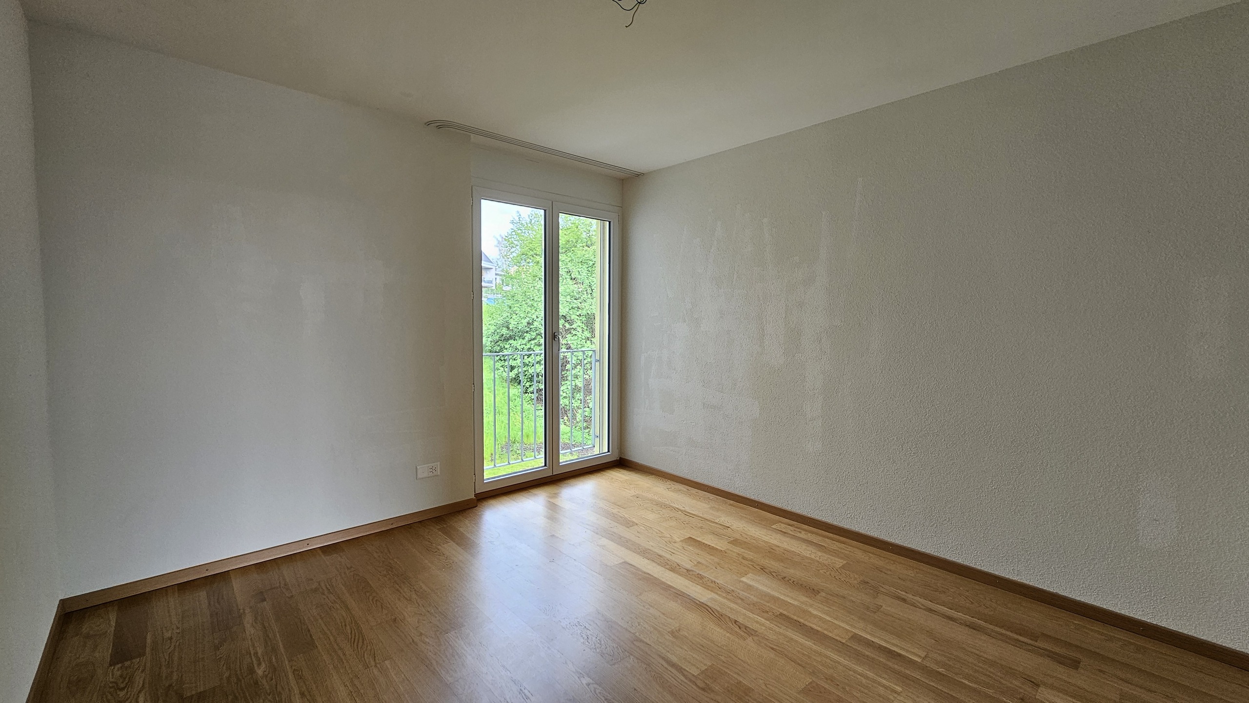Helles, leeres Zimmer mit Balkon- oder Terrassentür